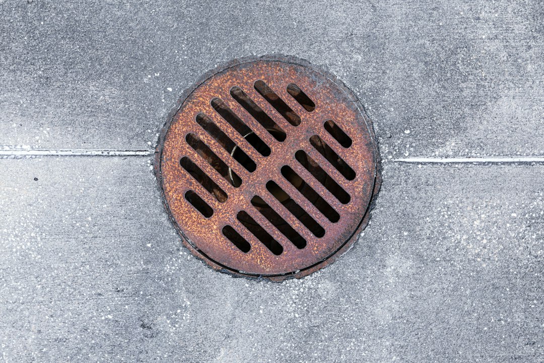 Round metal drain grate in a paved surface